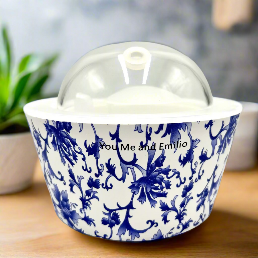 Ceramic container with blue floral pattern and clear lid on a white background