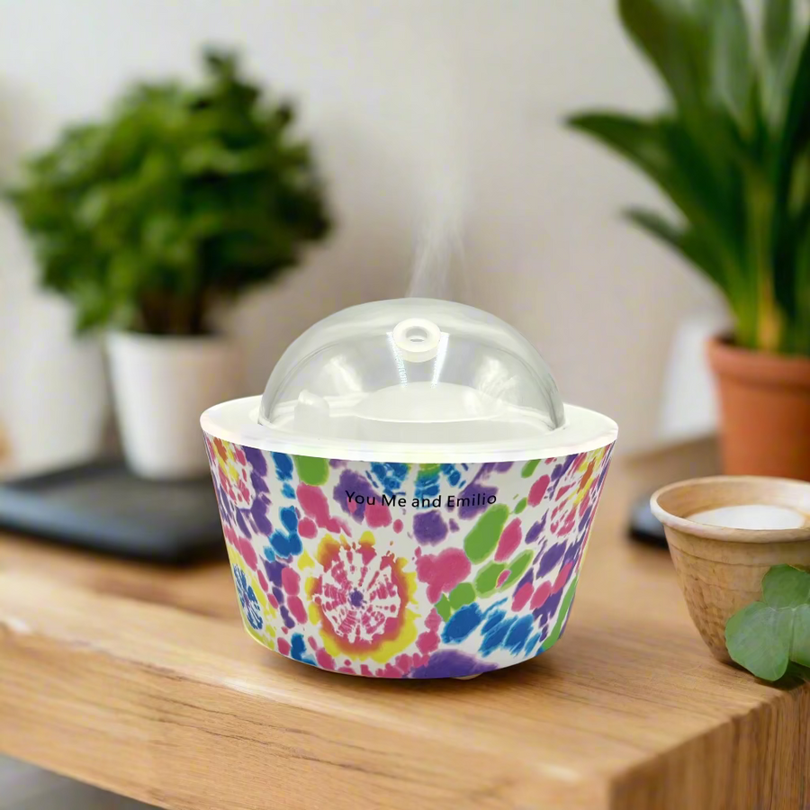 Colorful tie-dye container with a clear dome lid on a white background