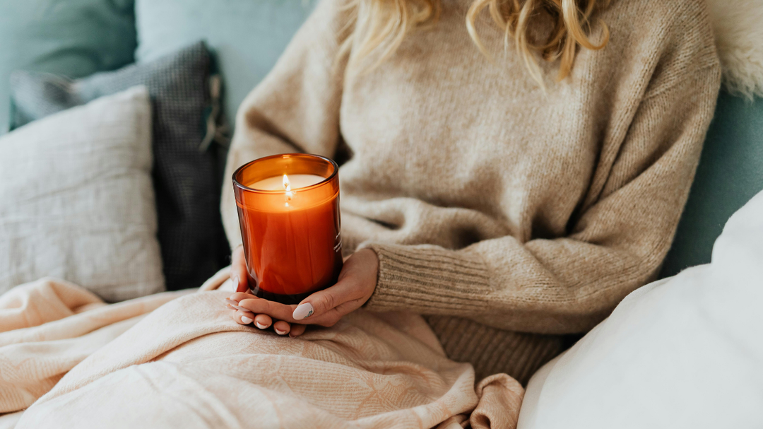 Cozy fall living room with glowing soy candles and warm blankets