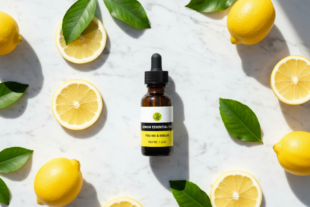 YOU ME & EMILIO Lemon Essential Oil pure amber dropper bottle surrounded by fresh lemons and lemon slices on marble