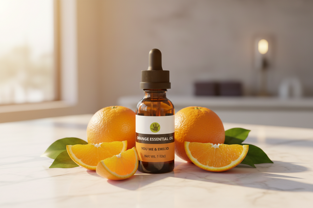 YOU ME & EMILIO Orange Essential Oil pure amber dropper bottle surrounded by fresh oranges and orange slices on marble
