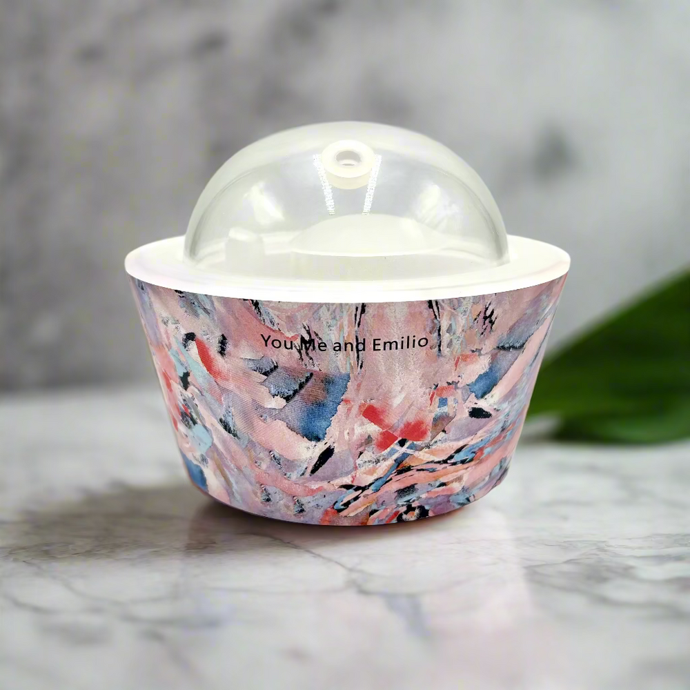 Decorative container with abstract design and clear dome lid on a white background