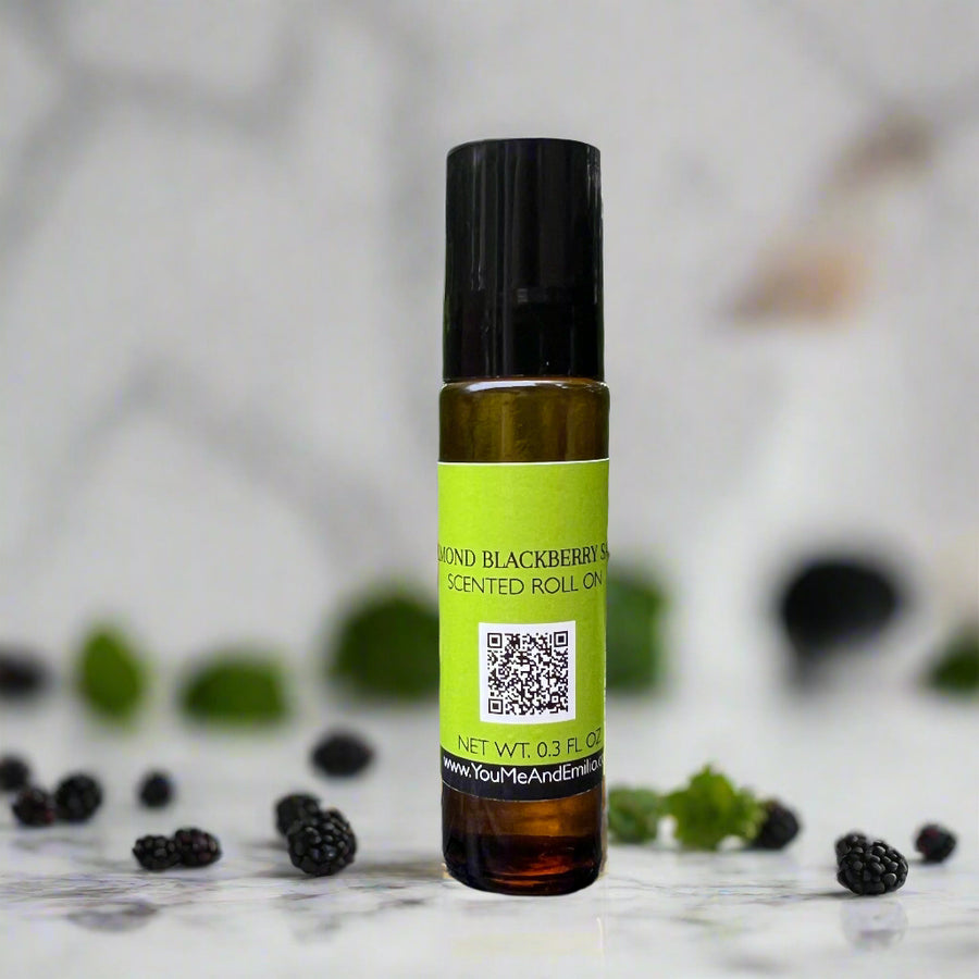 Amber bottle of Almond Blackberry Sage Roll-On Perfume Oil by You Me & Emilio, featuring notes of blackberry, sage, almond, and vanilla.