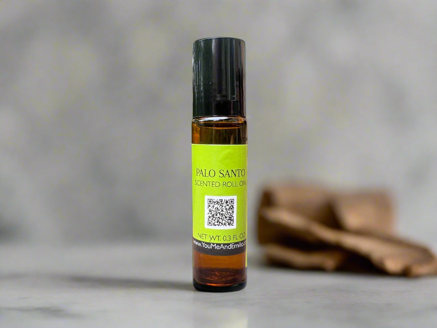 Amber glass bottle of Palo Santo Scented Roll-On by You Me & Emilio, featuring earthy palo santo wood fragrance oil for aromatherapy, grounding, and daily wellness rituals.