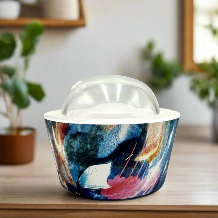 Colorful abstract-patterned container with a clear lid on a white background