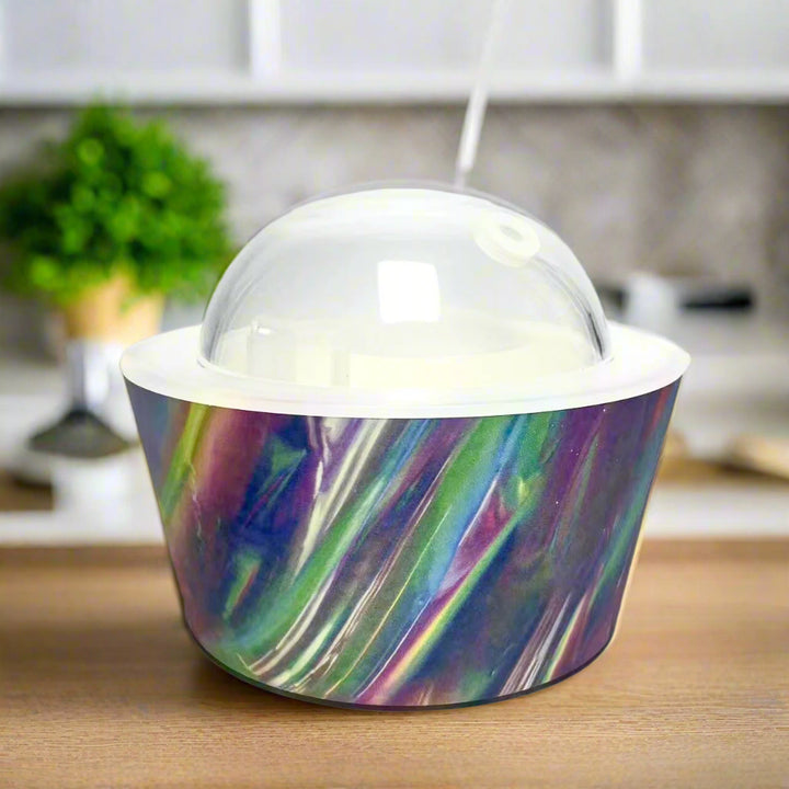 Celestial Oil Diffuser featuring cosmic swirls of blue, violet, and green with a clear dome top, designed by Emilio Horton for YOU ME & EMILIO, inspired by the sound of running water and mist.

