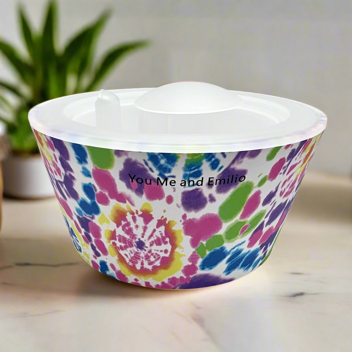 Colorful tie-dye patterned bowl with 'You Me and Emilio' text on a white background