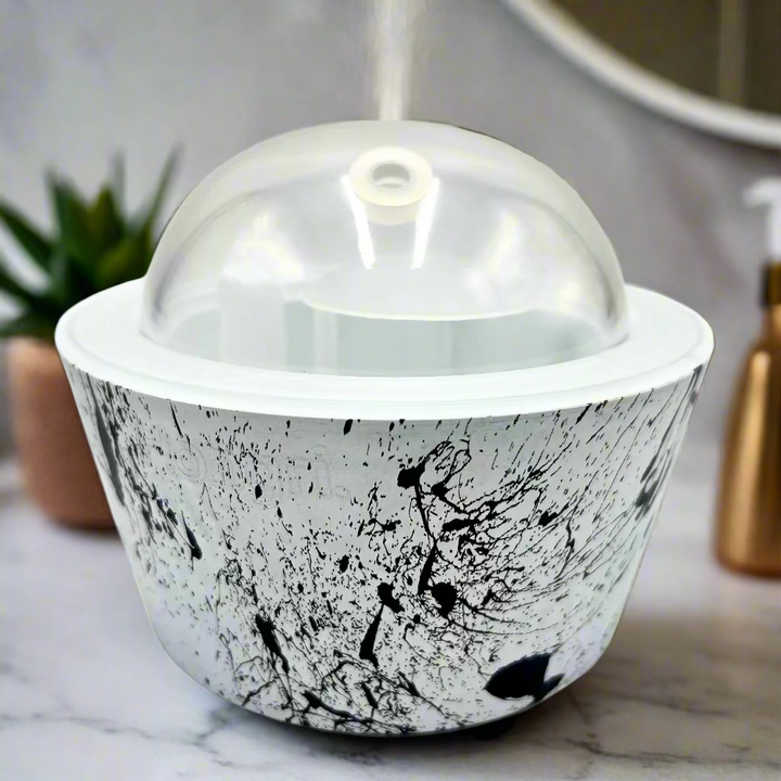 Ceramic bowl with black abstract design and clear lid on a white background