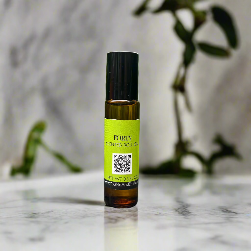 Amber glass bottle of Forty Scented Roll-On by You Me & Emilio, featuring bold musky and floral fragrance oil for daily wear, luxury scent rituals, and gifting.