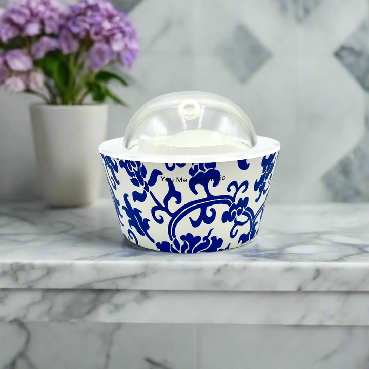 Blue and white ceramic container with a clear lid on a white background