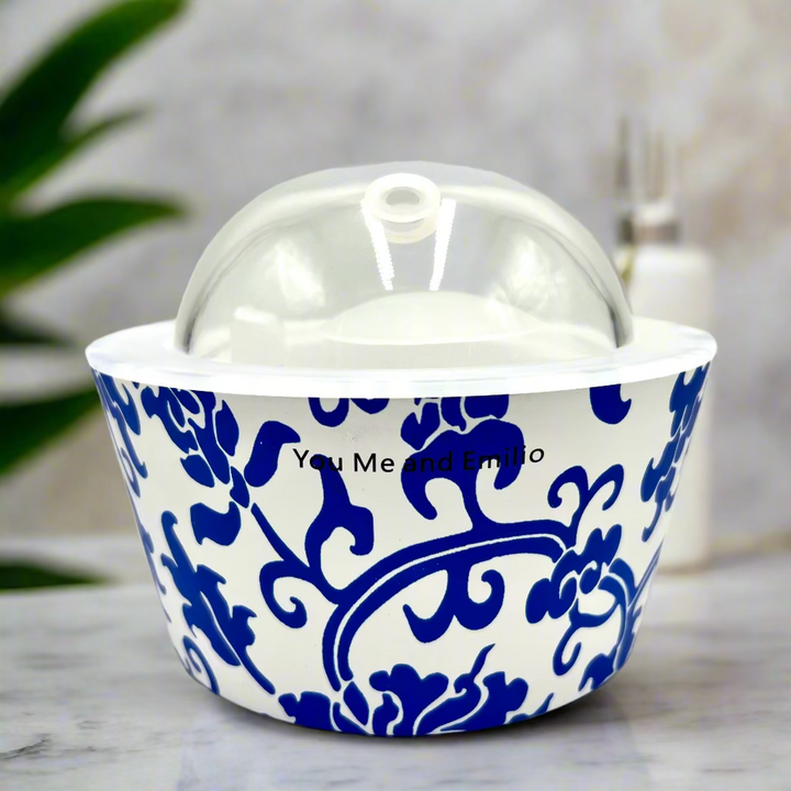Ceramic container with blue floral pattern and clear lid on a white background