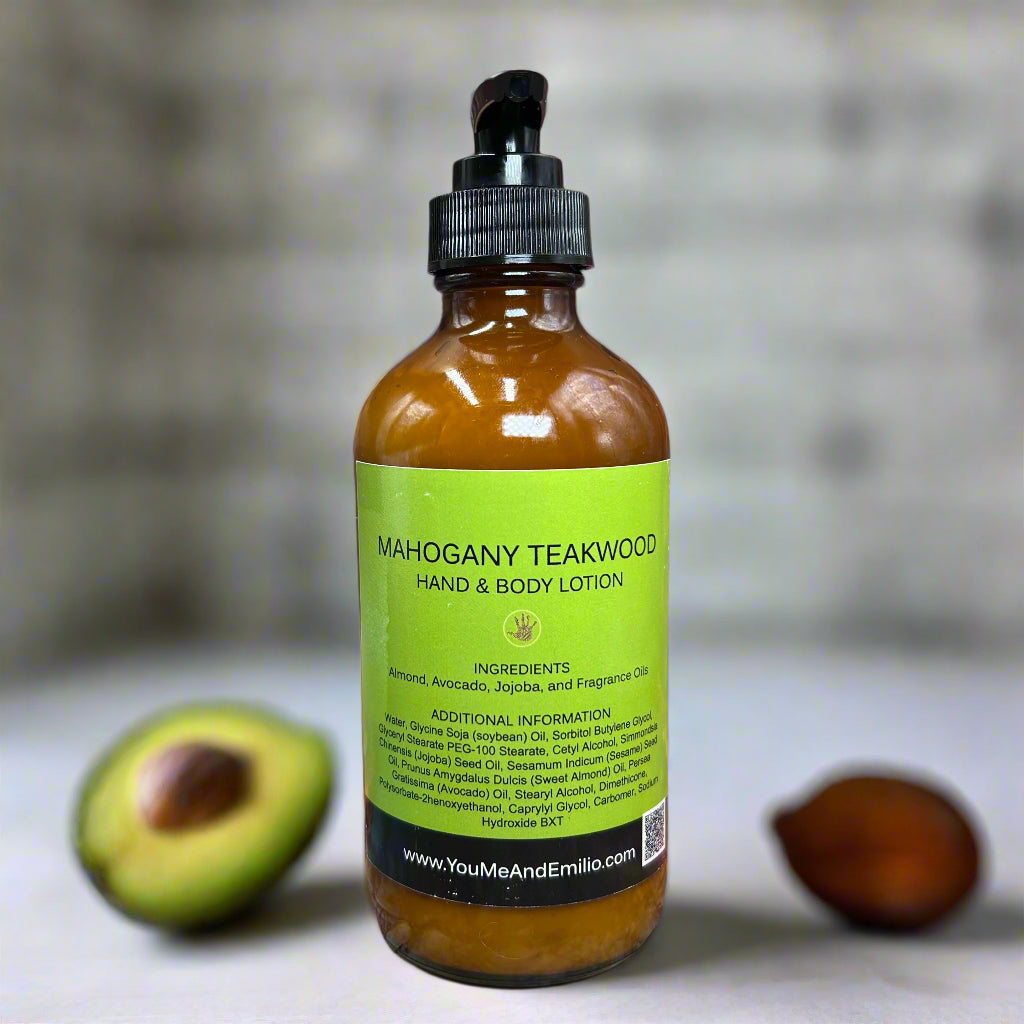 Bottle of Mahogany Teakwood Hand & Body Lotion standing amidst soft lighting, with drops of jojoba, almond, and avocado oils highlighting its nourishing ingredients.