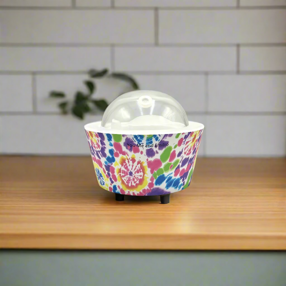 Colorful tie-dye patterned container with a clear dome lid on a white background