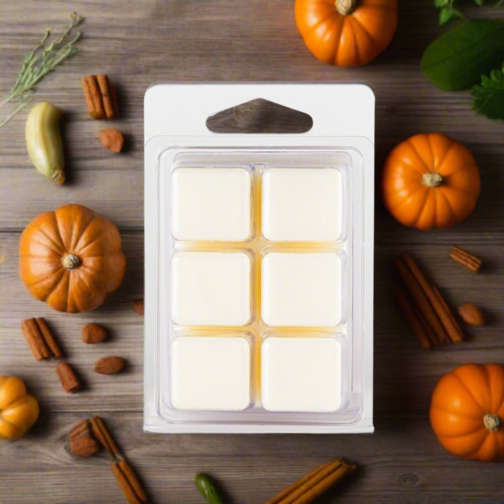 Pack of wax melts with pumpkins and cinnamon sticks on a wooden surface