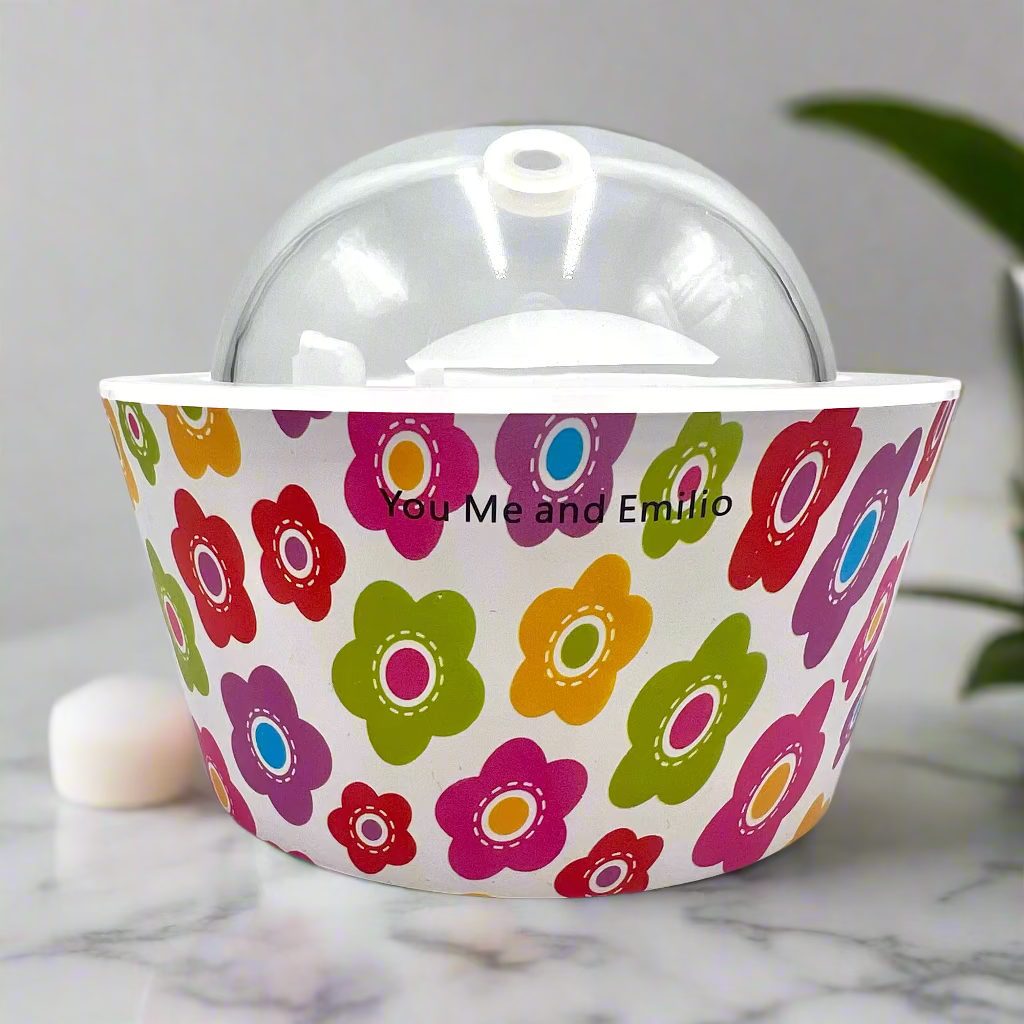 Colorful floral-patterned container with a clear dome lid on a white background