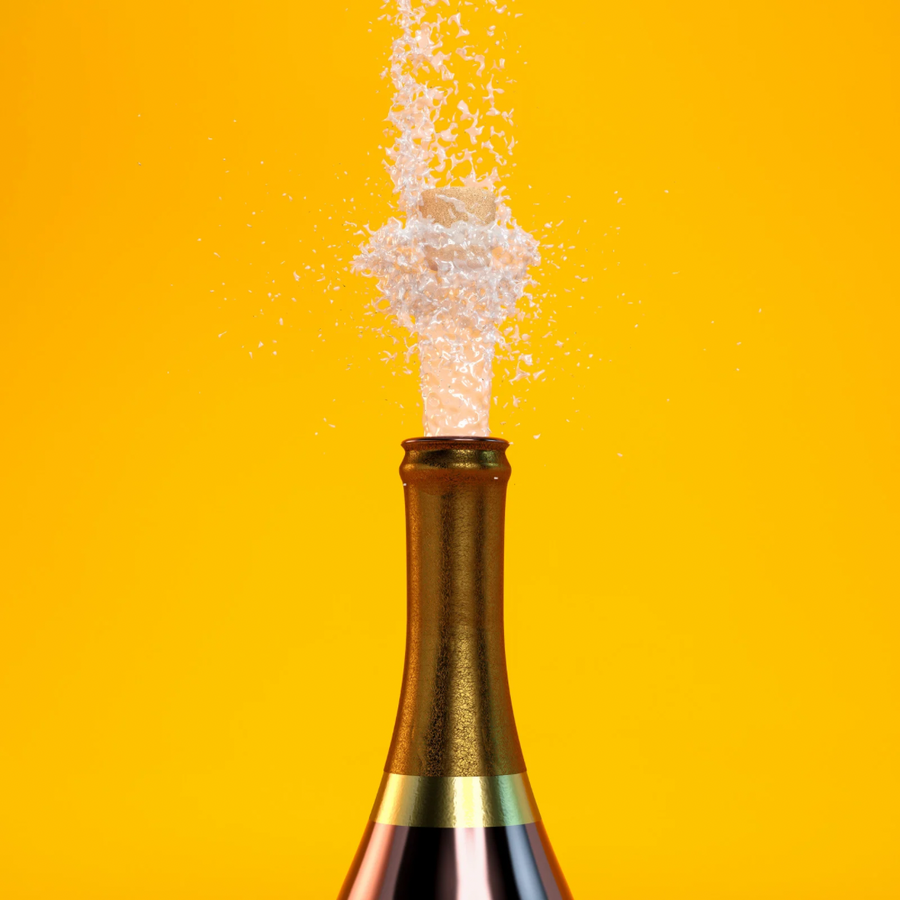 Bottle of champagne with cork popping against a yellow background