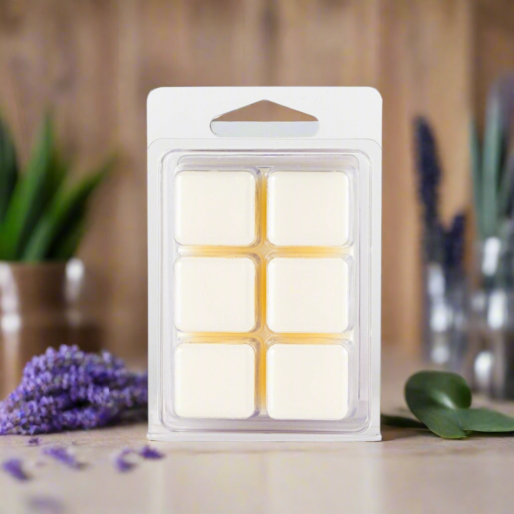 Pack of wax melts with a wooden background and plants