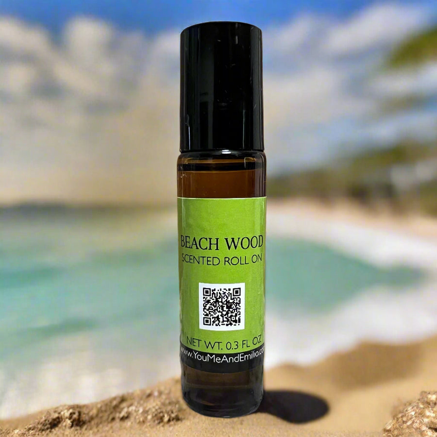 Amber bottle of Beach Wood Roll-On Perfume Oil by You Me & Emilio, featuring notes of vetiver, salt air, driftwood, and soft musk.