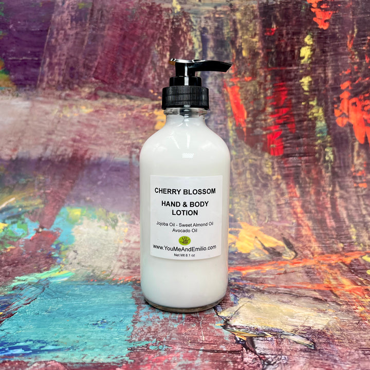 Cherry Blossom Hand & Body Lotion next to fresh cherries and blossoms, capturing its spring-inspired scent and luxurious feel.