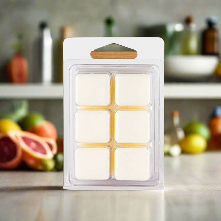 Pack of wax melts in a kitchen setting with fruits and bottles in the background