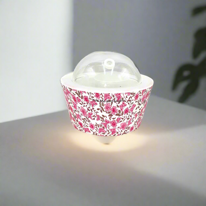 Cupcake liner with floral pattern and clear dome on a white background