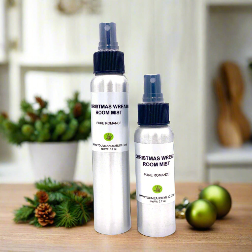 Christmas Wreath Room Mist in a sleek cylindrical aluminum bottle, surrounded by fresh pine sprigs, red berries, and festive holiday ornaments.
