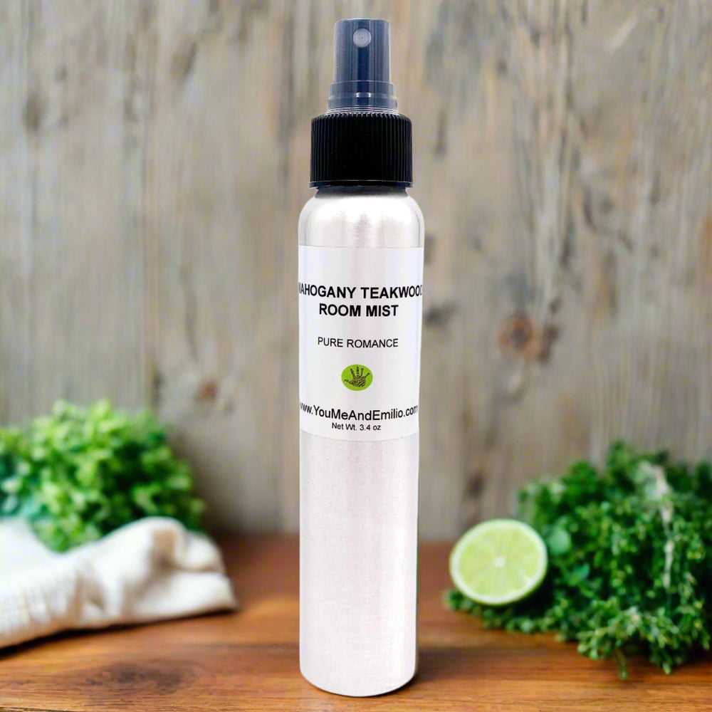 The Mahogany Teakwood Room Mist on a wooden table surrounded by cedar wood, oak, and lavender sprigs, showcasing the natural elements that inspire its rich and captivating scent.